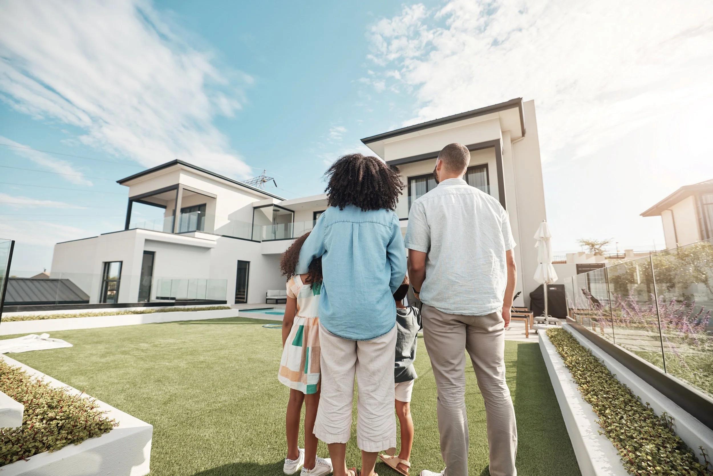 Family standing together looking at their new home
